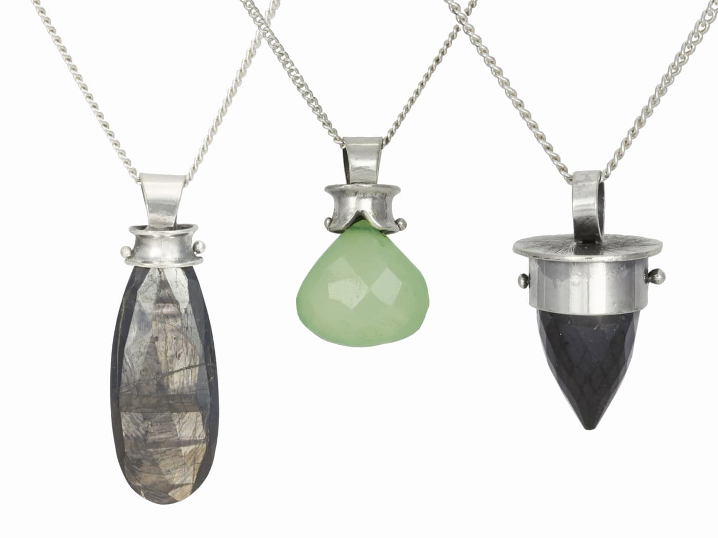 Coined metal drop pendants on a stone surface